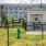 an enclosed dog park with a building behind it