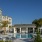 resort style pool with seating palm trees and a building beside