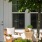 a white house with a patio and a tree