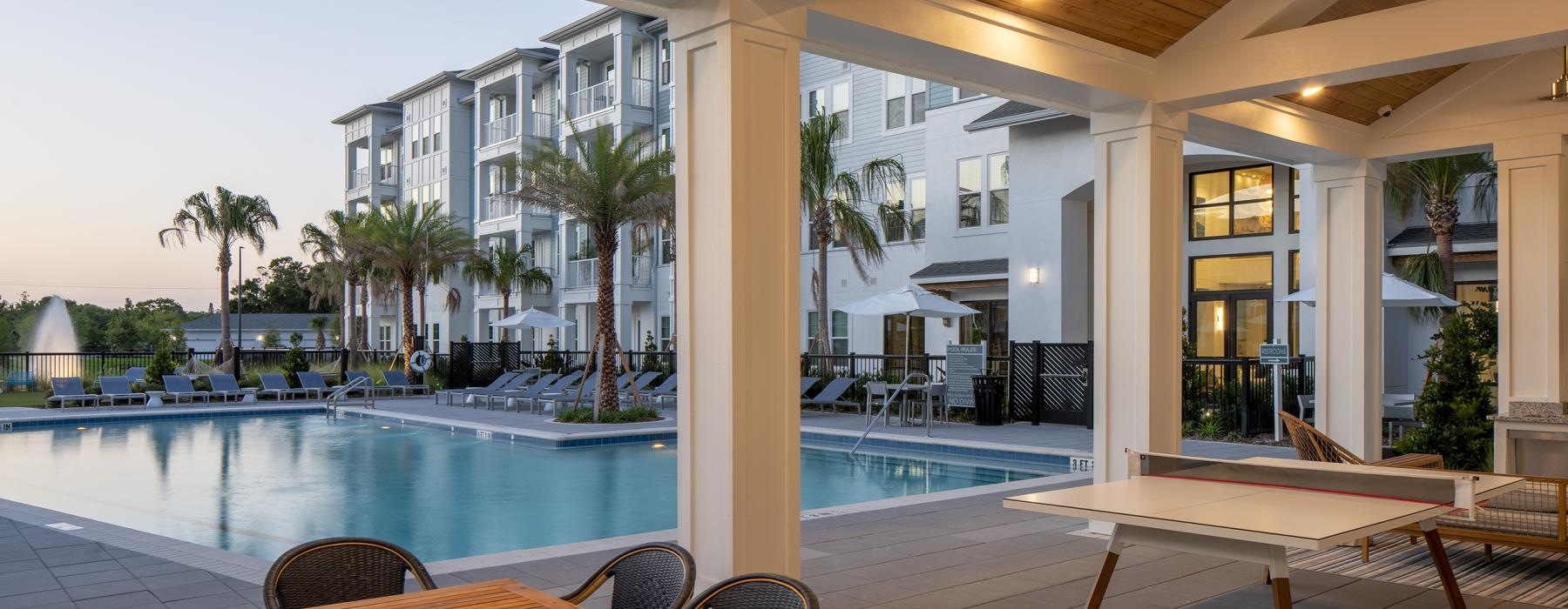 a pool with tables and chairs next to it