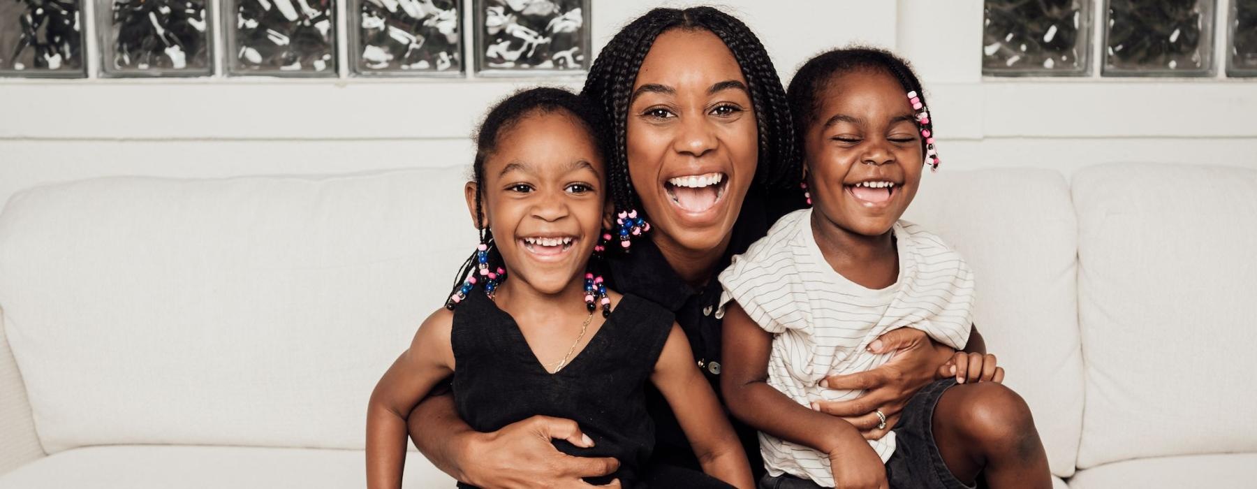 a woman sitting on a couch with two kids